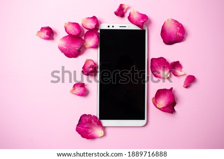 pink rose petals frame with mobile mockup on pink background. top view.
Valentine concept