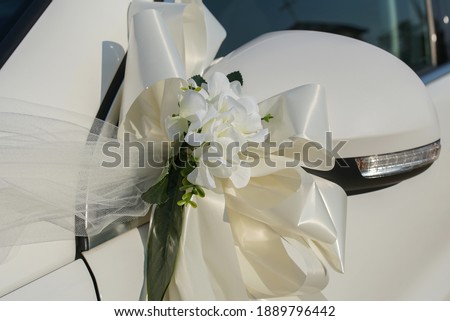 Satin scarves and flowers decorated on the wedding car. Wedding concept of decorating vehicles