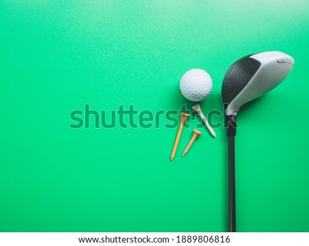 Golf equipment flat lay on green background. Top view