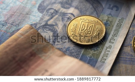 Warsaw, Poland 01.01.2021 - Close up one coin over Ukrainian hryvnia. Currency accounting and finances concept. High quality photo