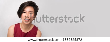Banner portrait of a smart beautiful middle aged asian woman (40-50) in red outfit smiling charming and cheerful isolated background. Beauty health care products, anti-aging, stylish short hair style.