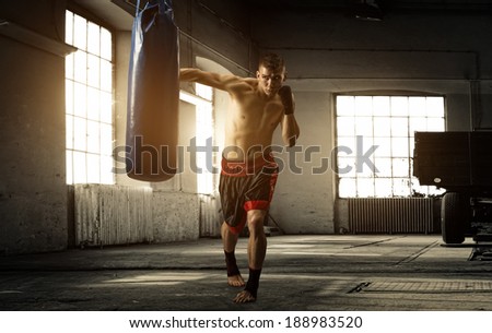 Young man boxing workout in an old building Royalty-Free Stock Photo #188983520