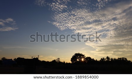 Gray and white clouds at sunset. Scenery and natural beauty of clouds in the sky with silhouettes of trees in winter after sunset in Thailand with copy space. Selective focus