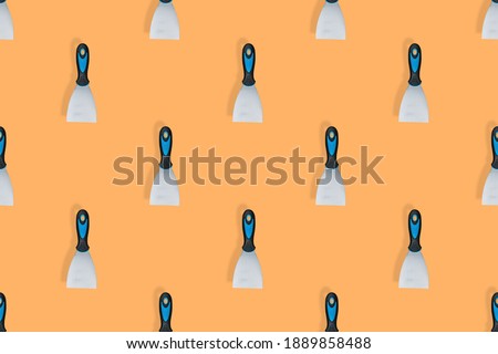 Putty trowel seamless pattern. Spatulas for on an orange background.