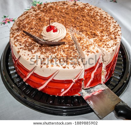 A delicious cake being sliced to share and celebrate some special occasion.