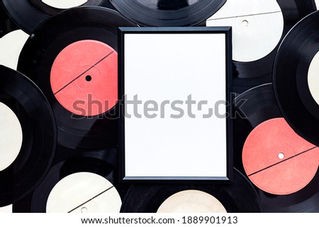 Retro style mock-up. Black frame for photos on the background of vinyl records.