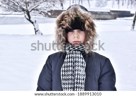 Sad boy in nature in winter. Winter concept. The kid walks in the fresh air. Cute boy in nature in winter. Royalty-Free Stock Photo #1889913010