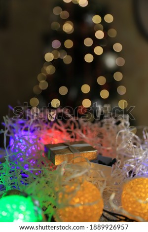 golden box with a gift on a Christmas background and bokeh from a Christmas tree