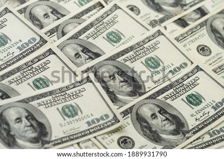A money pile of one hundred US banknotes with president Franklin portrait. Cash of hundred dollar bills, paper currency background.