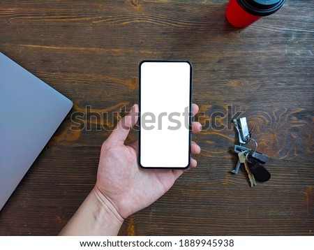 Smartphone mockup, coffee and keys on a wooden table. Top view