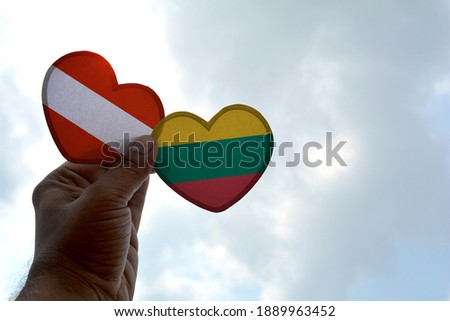 Hand holds a heart Shape Austria and Lithuania flag, love between two countries