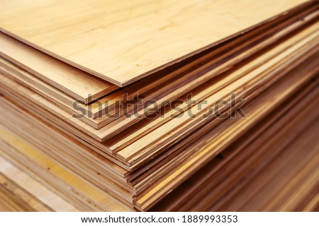 A lot of plywood sheets are stacked. Trade in wood building materials. Close-up Royalty-Free Stock Photo #1889993353