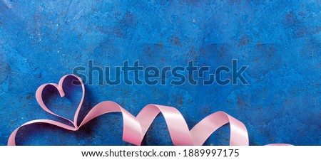 Valentines Day background with ribbons shaped hearts on blue. Valentines day concept. Valentine, love, holiday, romantic concept. Top view, copy space
