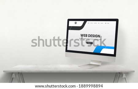 Web design studio desk with computer display and promo web page on it. Development team promotion concept Royalty-Free Stock Photo #1889998894