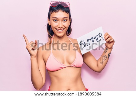 Young woman wearing summer hat smiling happy pointing with hand and finger to the side 