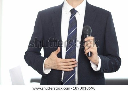 Cropped image of businessman speaking with microphone 
