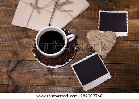Coffee cup and old blank photos, on wooden background