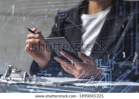 Businesswoman is signing the contract to create fin-tech start up for the conference and gain investments for innovative service. Checking the details at smartphone. Hologram tech graphs. Royalty-Free Stock Photo #1890045325
