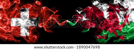 Switzerland, Swiss vs Wales, United Kingdom smoky mystic flags placed side by side. Thick colored silky abstract smoke flags.