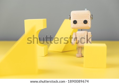 wooden robot toy. environmentally friendly toys for children. on a yellow and gray background, with yellow geometric shapes