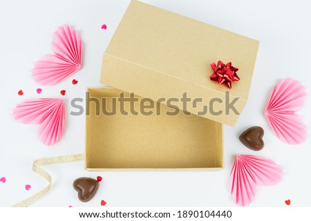 Cardboard box with paper hearts and chocolates Concept of Valentine's Day, anniversary, mother's day and birthday greetings. Copy space. Mockup.
