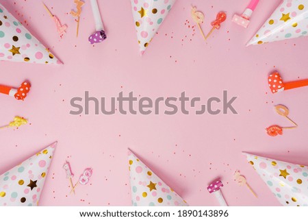 Party hat and candles lying on pink background. Birthday, holiday concept.