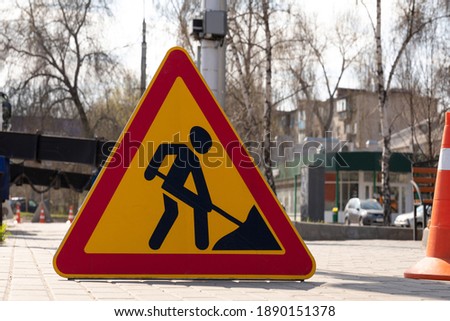 Roadworks warning sign ahead on street sidewalk. Close-up