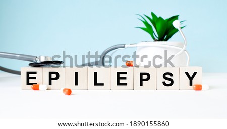 The word EPILEPSY is written on wooden cubes near a stethoscope on a wooden background. Medical concept