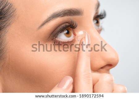One woman holds contact lens on her finger. Eye care and the choice between the means to improve vision.