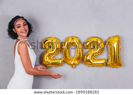 afro woman with balloons with number 2021. Concept of beginning of year
