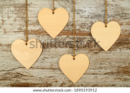 Valentine's Day background. 4 wooden hearts hung with string on a background of pickled old wood. Valentine's day concept. Flat view, top view, copy space