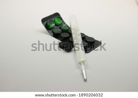 High Angle View Of Medicines And Thermometer On Wooden Table