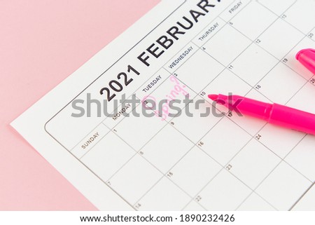 Groundhog Day concept. The word Spring is written on the calendar on the date 02 February. Pink background. Flat lay.