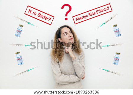A serious woman with questions and doubts with covid-19 vaccine bottles and It is Safe and Allegic Side Effects signs. Royalty-Free Stock Photo #1890263386