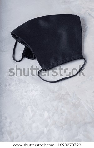 Face protective mask on ultimate gray background. Antivirus mask made from cotton. Black face homemade mask. Copy space