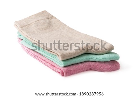 Stack of new tall colorful socks isolated on a white background. Three pairs of beige, green and pink socks folded in half. Elastic cotton hosiery. Full depth of field. Front view. Royalty-Free Stock Photo #1890287956