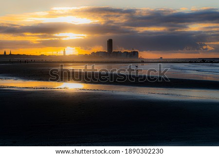 Golden hour belgium coastline with sea gulls and the sun and the silhoutte of city Ostend.  Coastline bredene of the north sea with sunset.  Beautifull belgium toerism,  wallpaper of flanders, yellow 