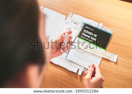Female holding COVID-19 swab collection kit Home free NHS check test kit, reading instructions before testing Royalty-Free Stock Photo #1890312286