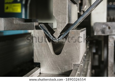 Working with sheet metal and special bending machines. hydraulic press brake or bending machine for sheet metal. Royalty-Free Stock Photo #1890326554