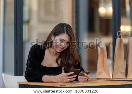 asian girl sit use smartphone enjoy easy bank payment service deliver shopping bags online store hold credit card