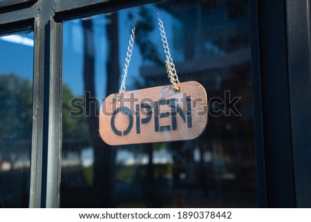 A business sign that says ‘Open’ on cafe or restaurant hang on door at entrance. Vintage color tone style.