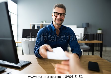 Executive Hand Giving Payment Check Or Compensation Cheque Royalty-Free Stock Photo #1890415153