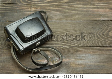 Old vintage film photo camera on a wooden background.