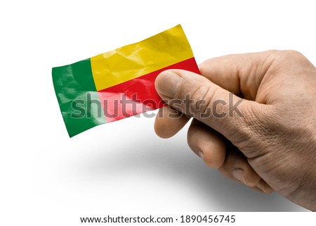 Hand holding a card with a national flag the Benin