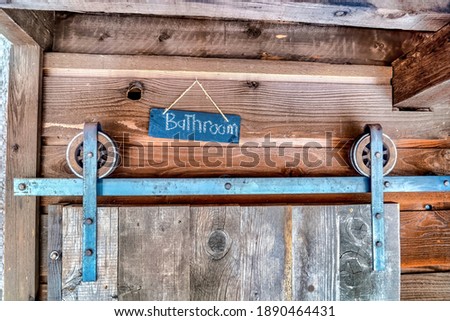 Bathroom entrance with wooden door sliding through wheels and metal track