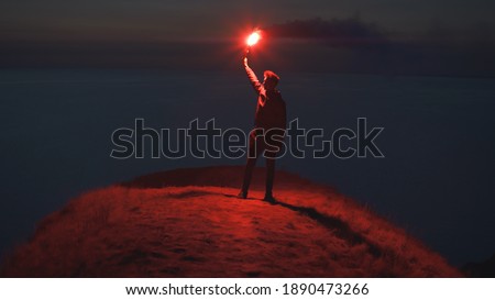 The man holding a fire stick on the mountain top near the sea Royalty-Free Stock Photo #1890473266