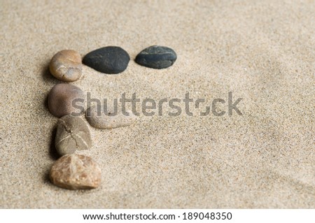 F with pebbles in the sand