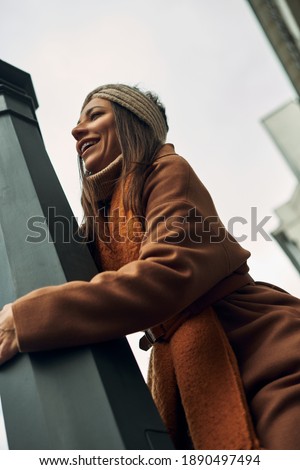 The girl poses near a street post. Walks and entertainment, photo session in the city