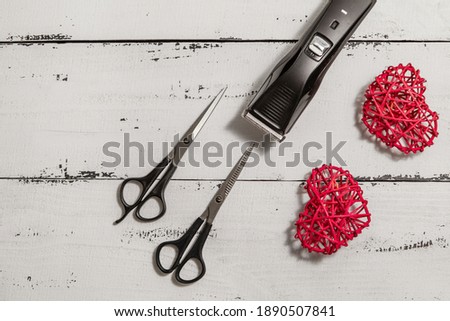 composition with hairdressing tools and colored rattan hearts on a worn white wooden background. Template for a postcard or information about a hair salon. flat lay, copy space