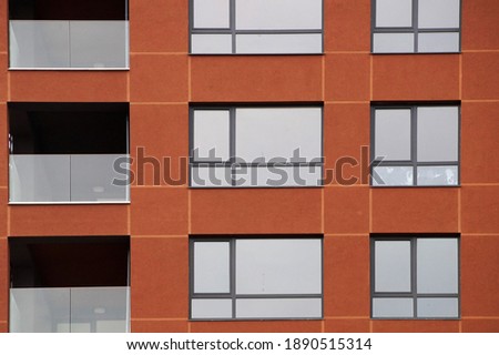 terracotta modern facade of the house with windows and loggias.